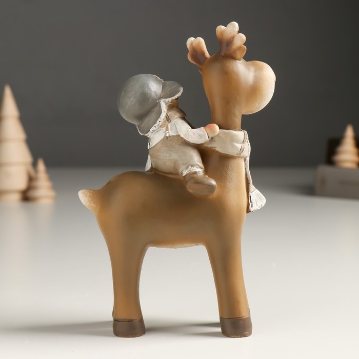 Сувенир полистоун "Малыш в шапке-ушанке верхом на лосике" беж 6х11х14 см